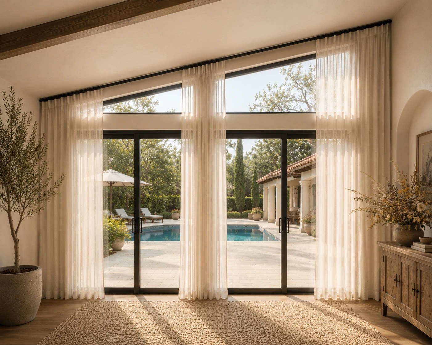 Virtual design of warm ivory center-opening ripple-fold sheer drapery following a sloped and angled ceiling in a Santa Barbara-inspired Spanish Revival interior.