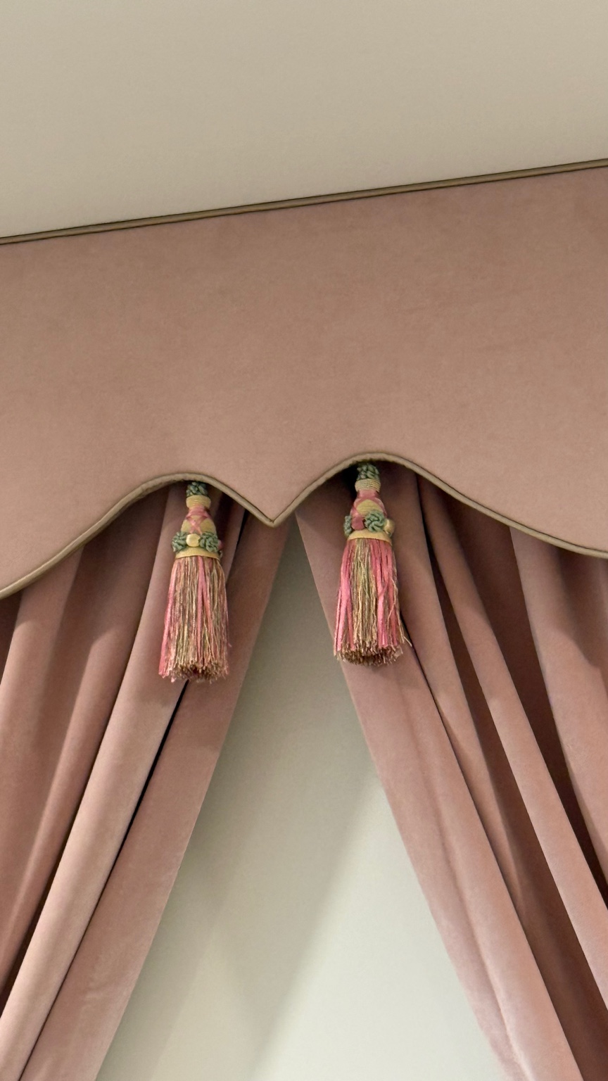 Custom blush upholstered cornice with piping and tassel detail