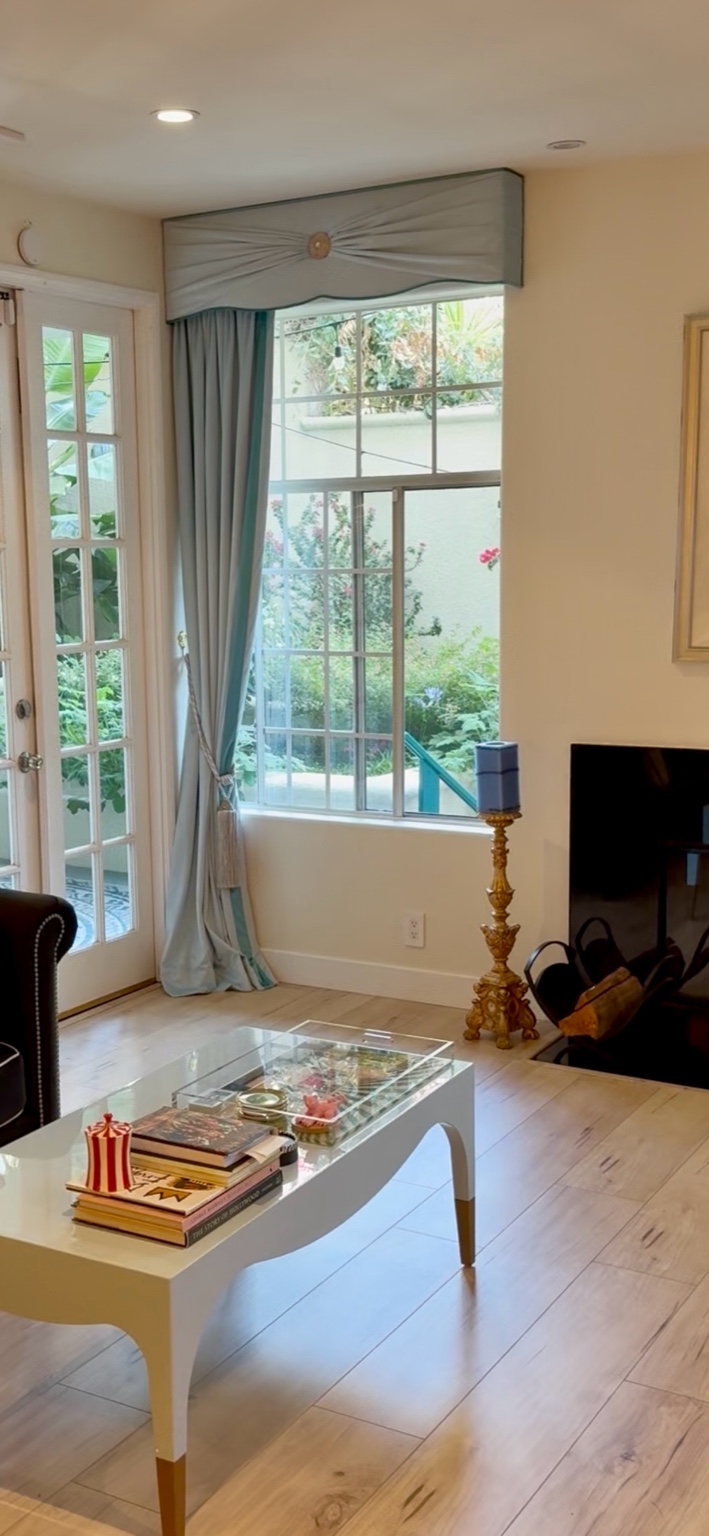Left powder blue velvet drapery treatment beside fireplace in Beverly Hills condominium