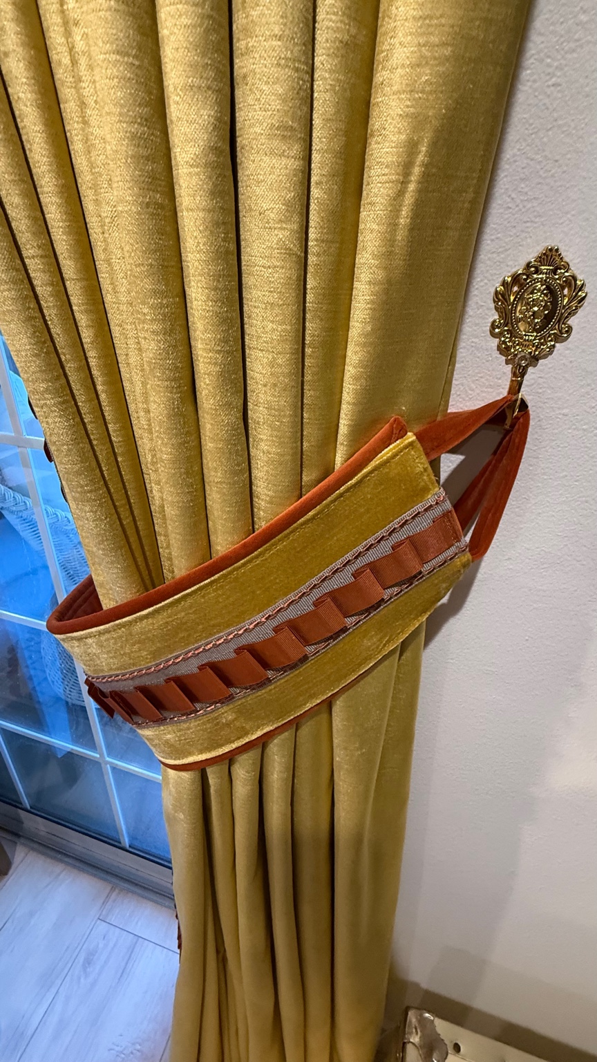 Custom tieback with rust toned trim on sunflower velvet drapery