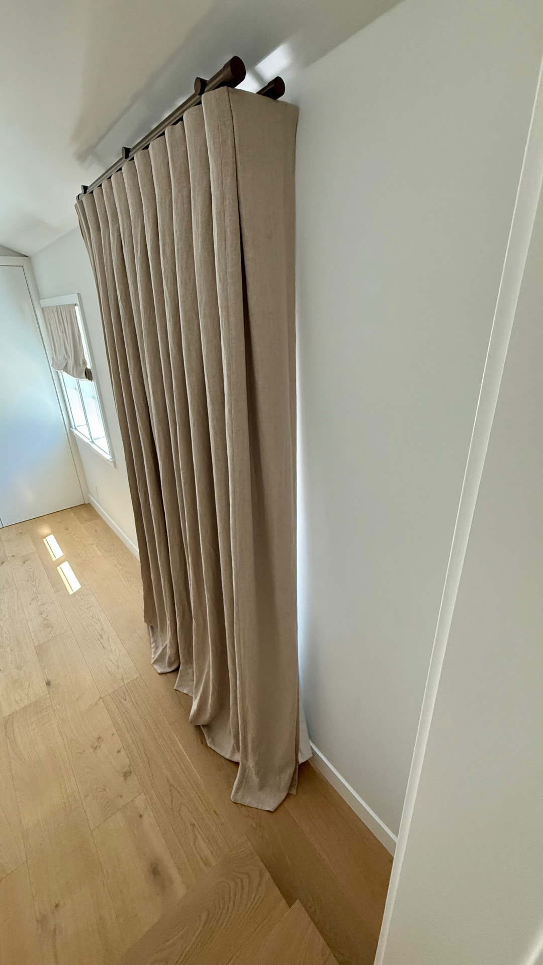 Floor-length linen drapery on bronze hybrid rod track in Venice California