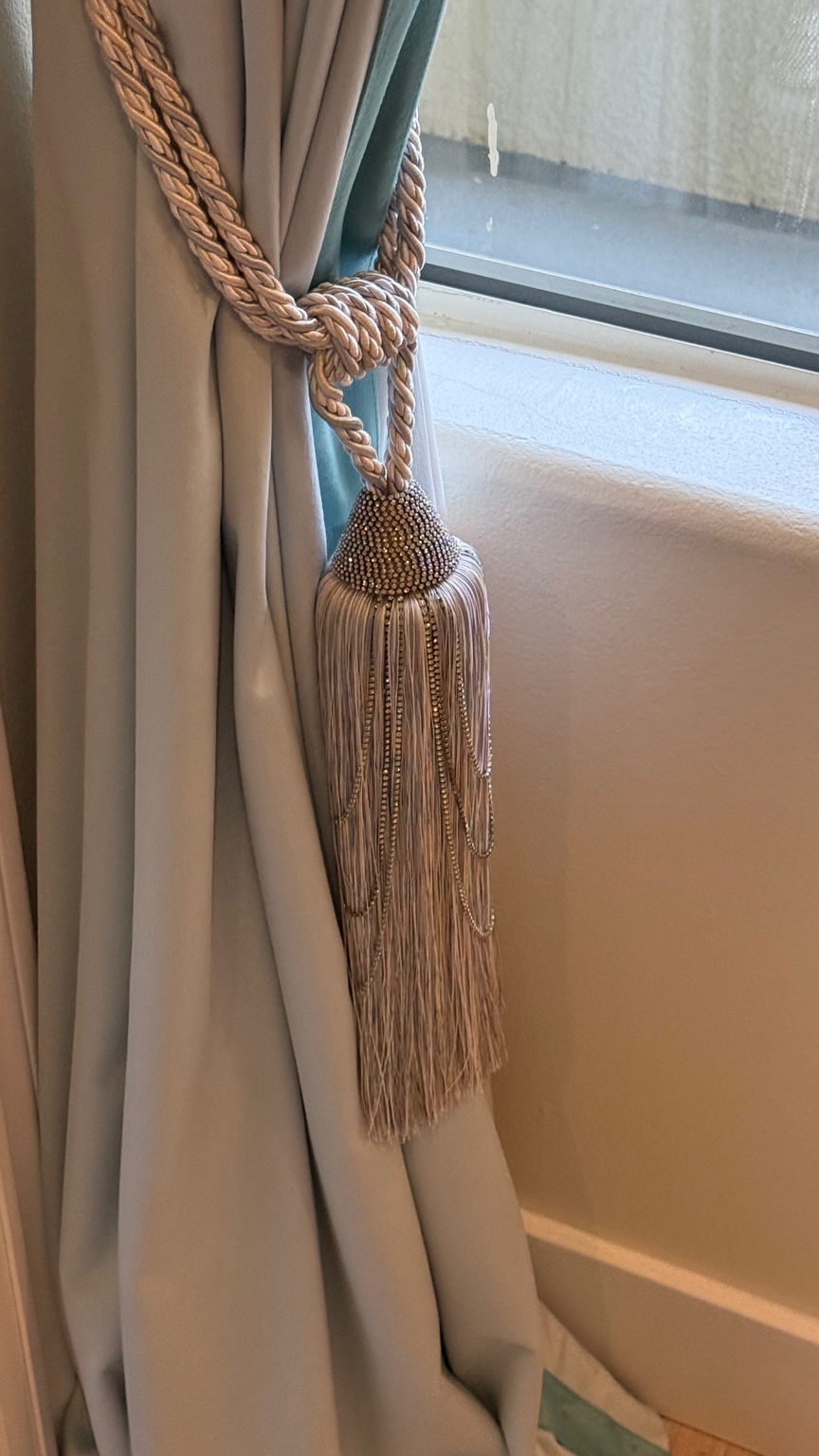 Decorative tassel cord and teal detail on powder blue velvet drapery